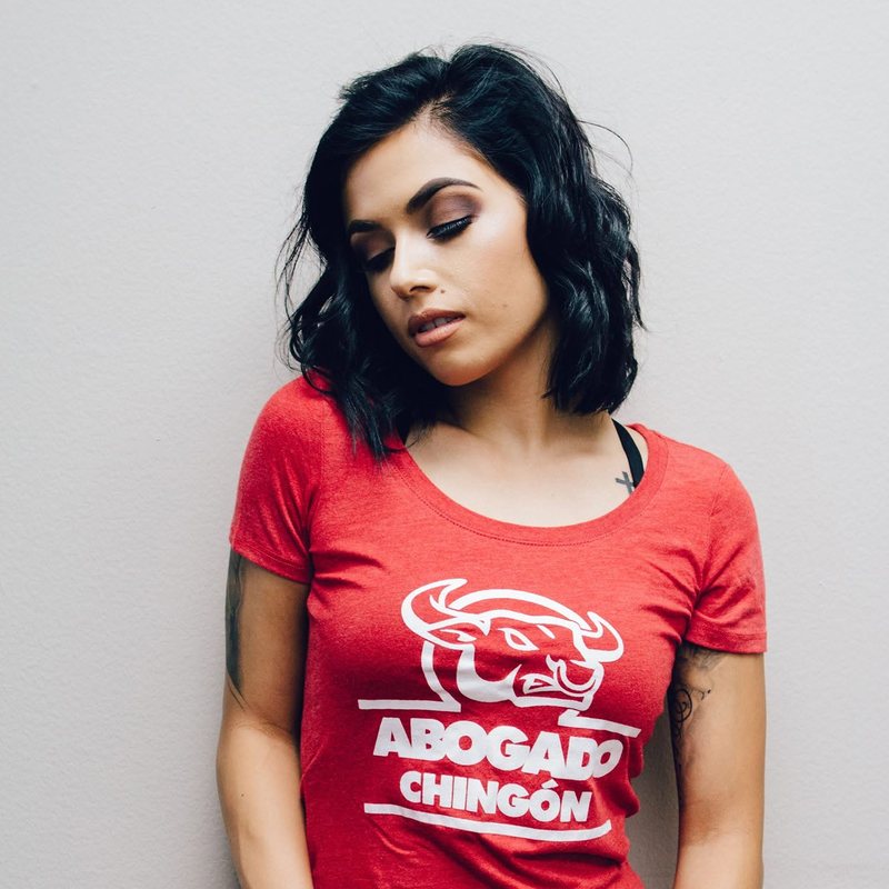 Model in a red Abogado Chingón tee in the studio