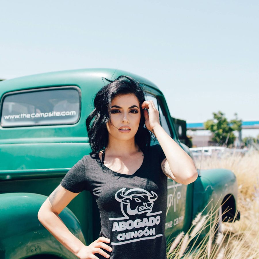 Model in a black Abogado Chingón tee next to a classic truck